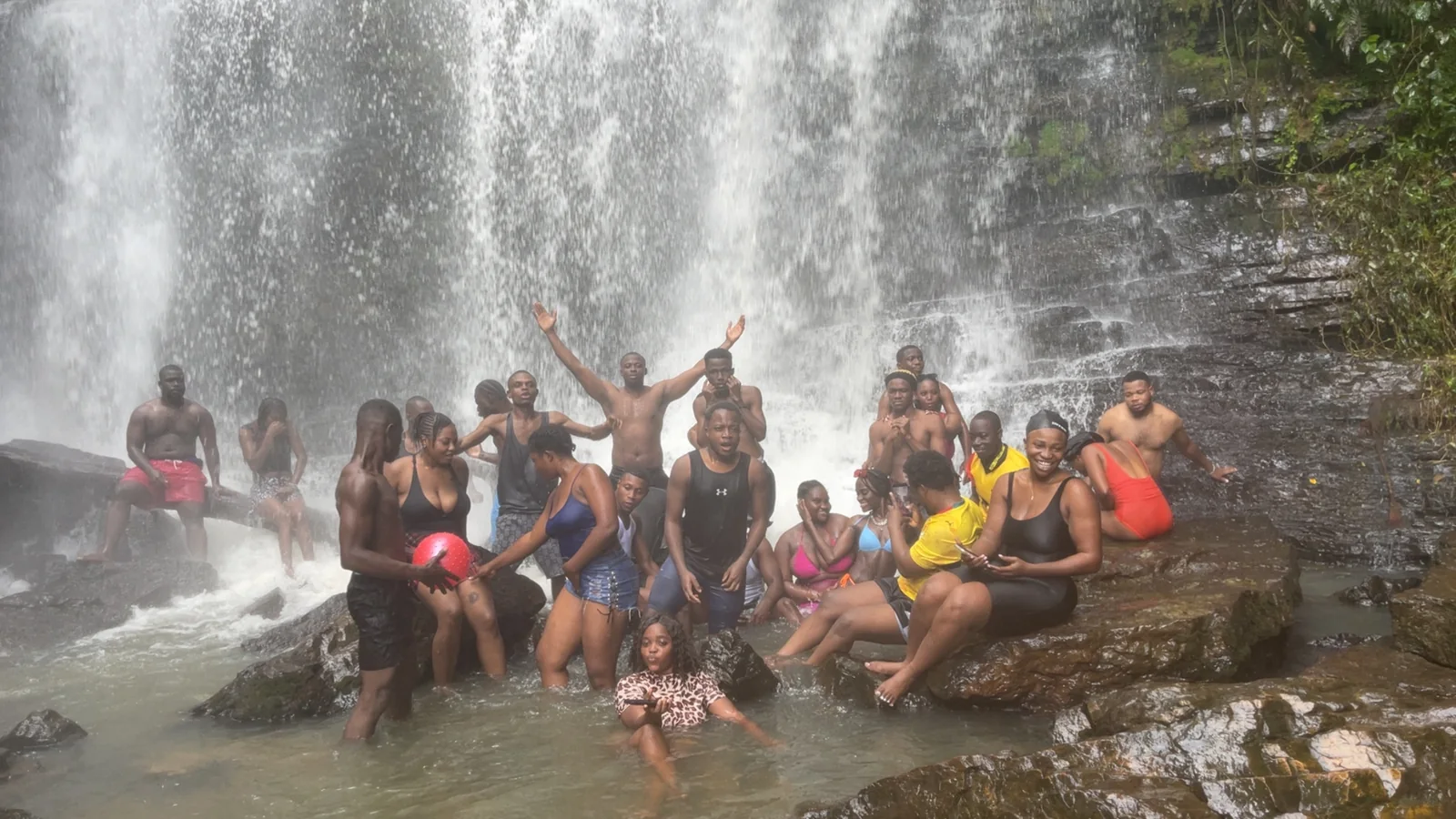 Oboadaka travellers gathered beneath the waterfall